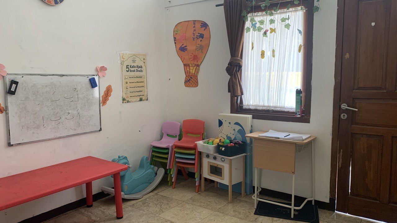 Ruang kelas Preschool dengan meja kegiatan dan area bermain anak